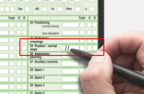 Examiner writing in box number 25 on the driving test report sheet